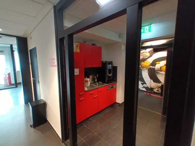 [:en]The kitchen of the capsule hotel seen through the glass door.[:]