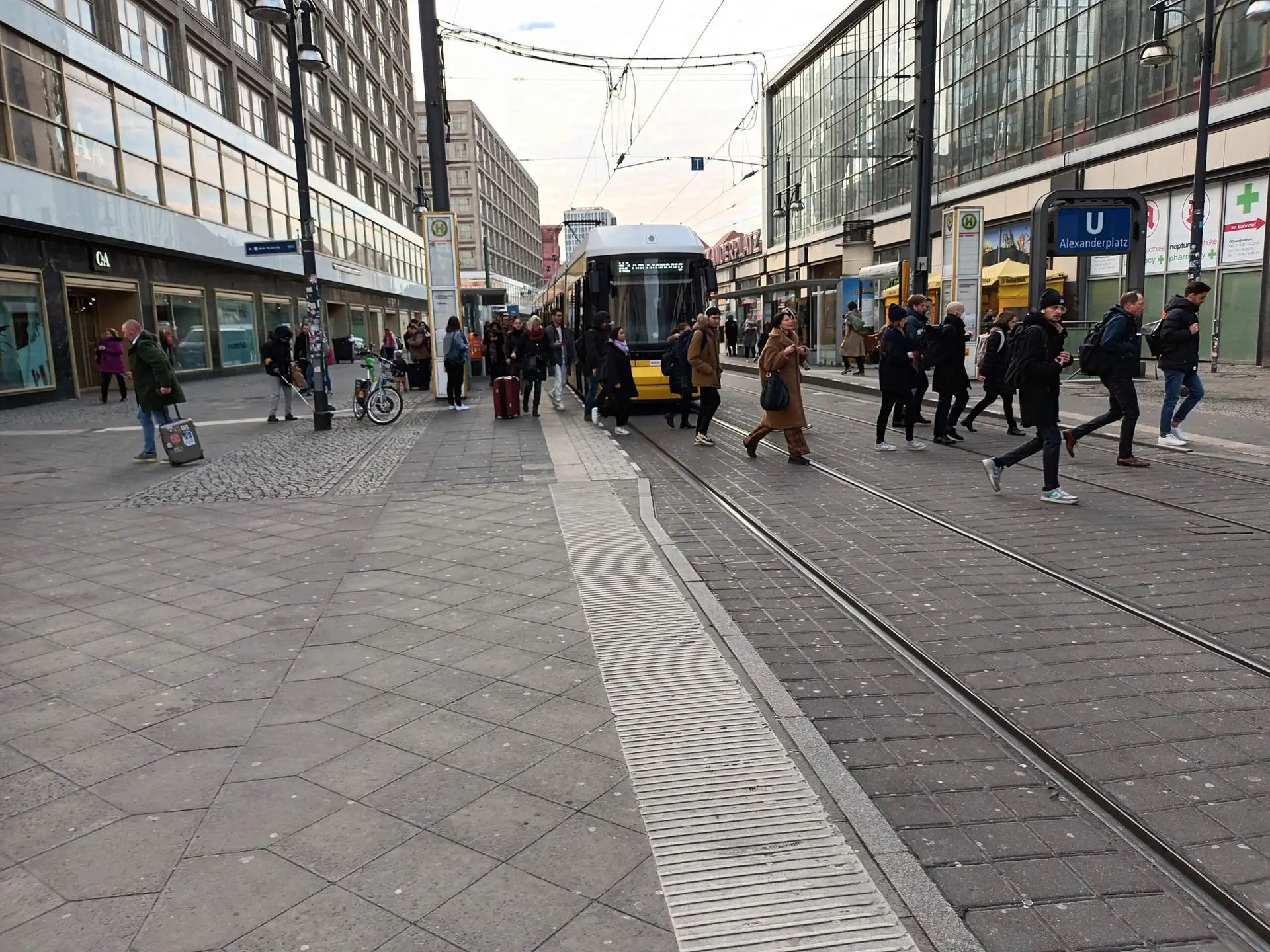 [:en]Street view in Berlin. A tram and people crossing the street.[:]