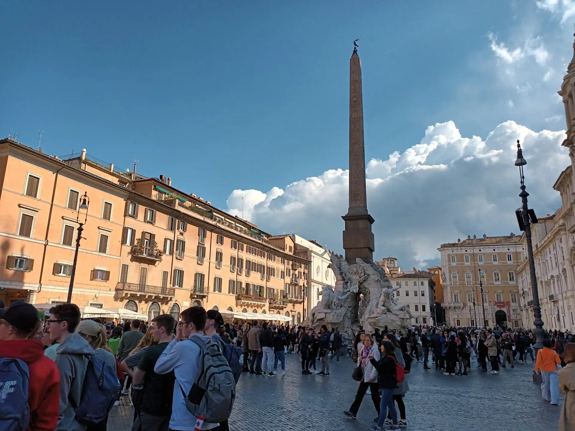 [:en]Market square in Rome. Tall pole and people.[:]