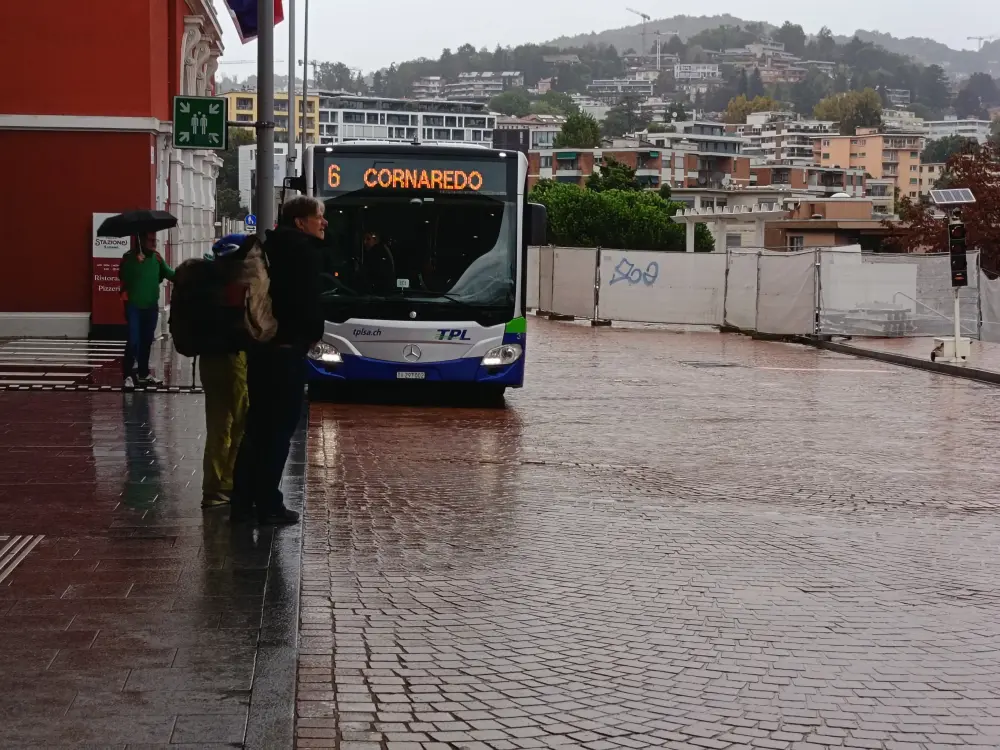 People are waiting for the bus in front of the Lugano travel center