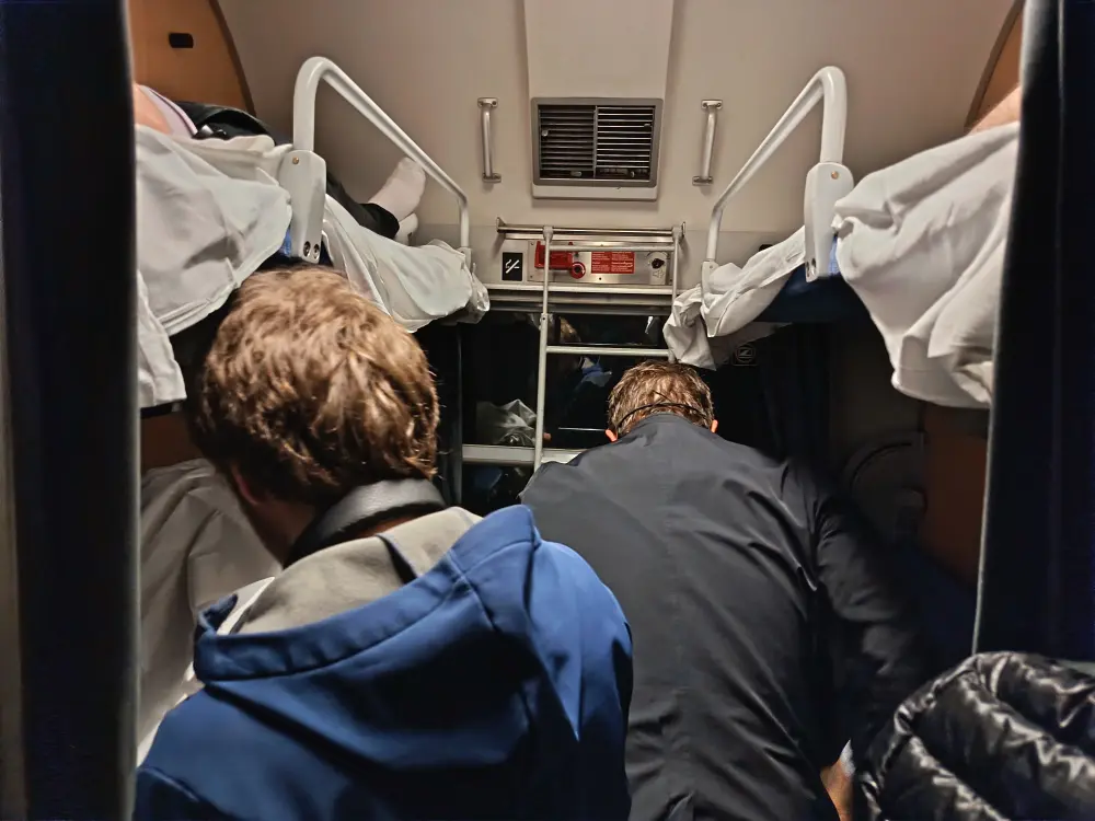 The people traveling in the train's sleeping car prepare the beds for the night.