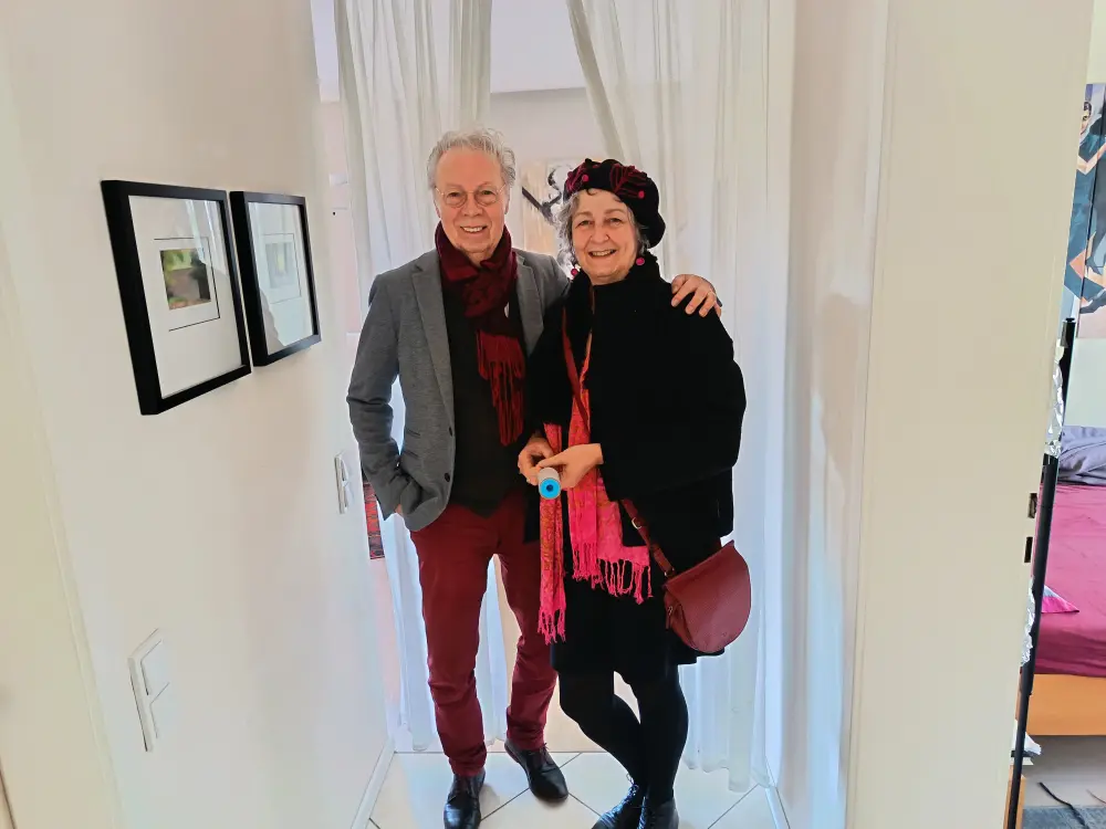 A man and a woman are standing in the hallway in outerwear.