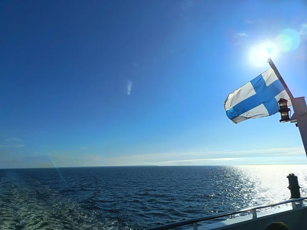 On the ship's deck. The Finnish flag is flying.